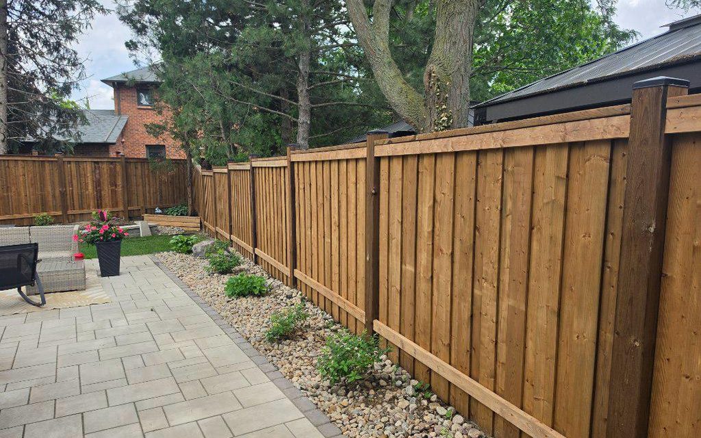 Wood privacy fence bordering a backyard paver patio at a GTA home